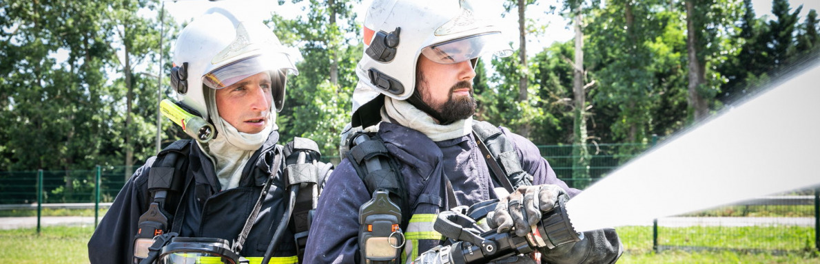 Deux sapeurs-pompiers projetant de l'eau